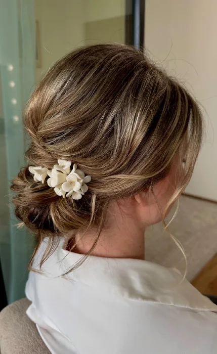 Hairstyling s nízkým drdolem a květinami