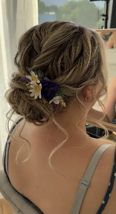 Hairstyling s nízkým drdolem a živými květy